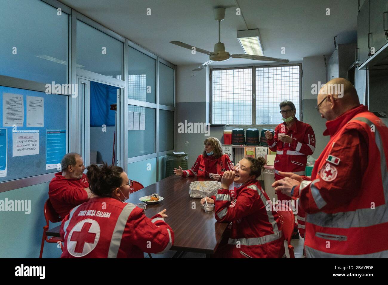 Milan, Italie. 27 mars 2020. Les bénévoles sont vus déjeuner à leur bureau. En raison de l'urgence de Covid-19, l'unité de crise du Comité de la Croix-Rouge aide les citoyens qui ont besoin d'aide dans plusieurs municipalités, ils offrent des commissions comme l'approvisionnement alimentaire et médical, les livraisons de repas préparés dans les hôpitaux et les services d'ambulance. Crédit: Valeria Ferraro/SOPA Images/ZUMA Wire/Alay Live News Banque D'Images