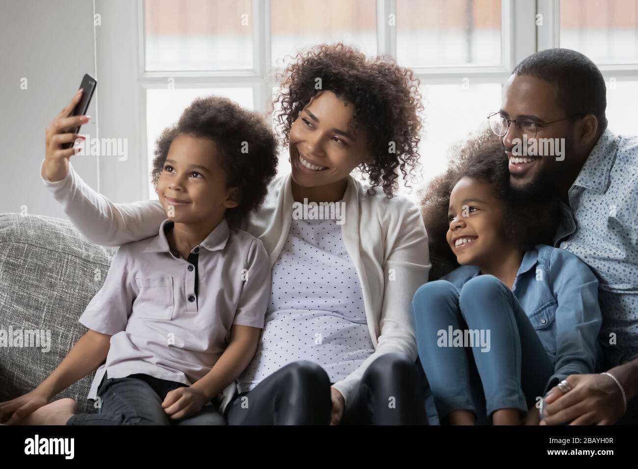Famille ethnique africaine avec des enfants prenant une photo égoïste à l'aide d'un smartphone Banque D'Images