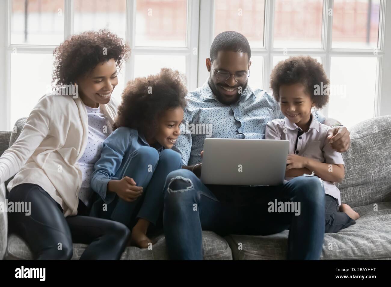 Une famille africaine complète utilisant un ordinateur portable s'amuser en ligne à la maison Banque D'Images