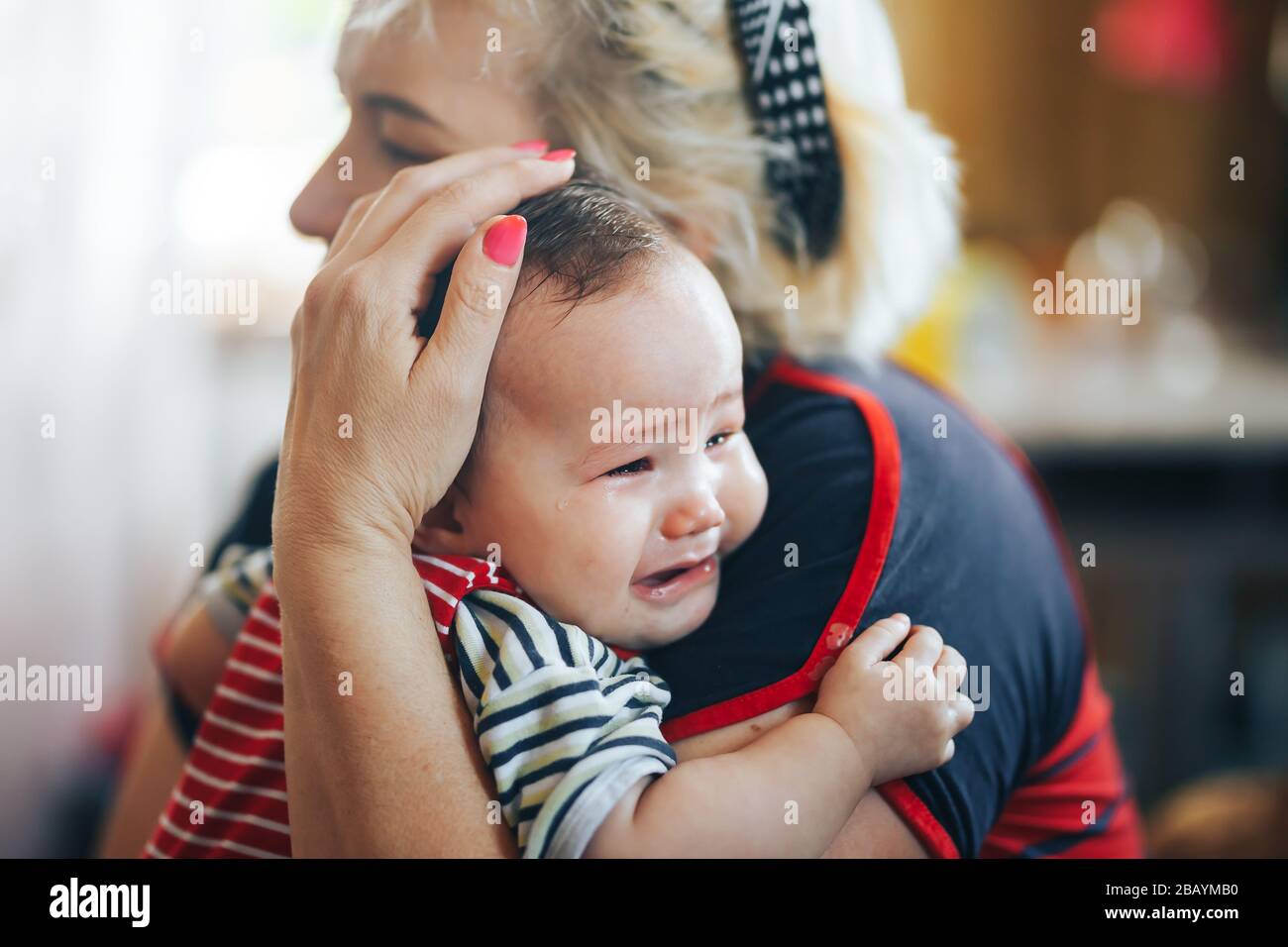 Grand-mère bercler bébé fille regardant l'appareil photo Banque D'Images