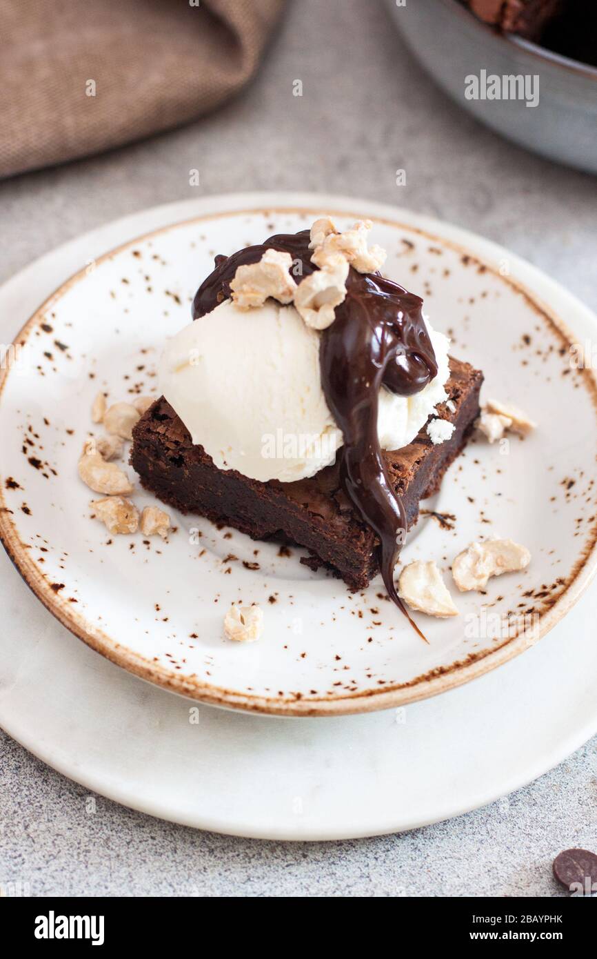 Brownie maison avec une boule de glace à la vanille, sauce au chocolat et noix Banque D'Images