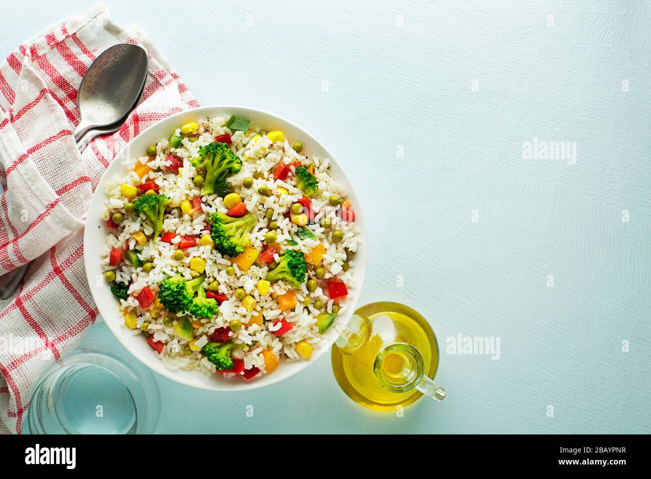 Salade de riz frais avec légumes mélangés dans un bol sur la table bleue Banque D'Images