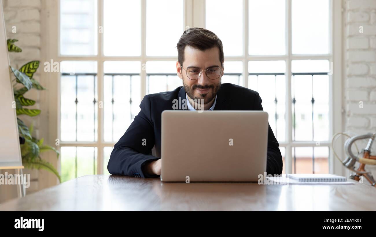 Homme d'affaires utilisant des applications professionnelles travaillant sur un ordinateur portable sur le lieu de travail Banque D'Images