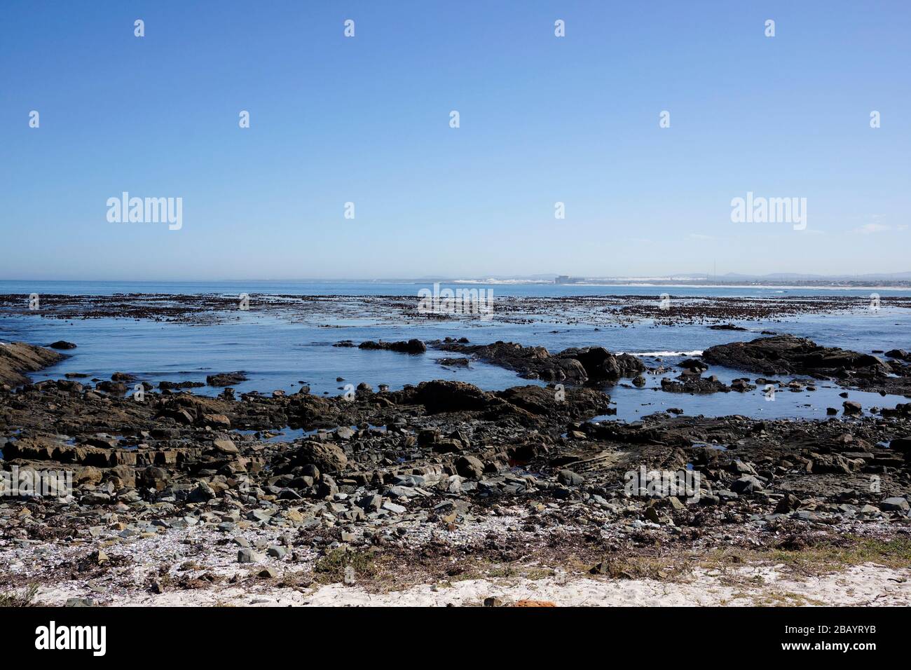 La plage de Melkbosstrand, près de Cape Town, avec la centrale nucléaire de Koeberg en arrière-plan. Banque D'Images