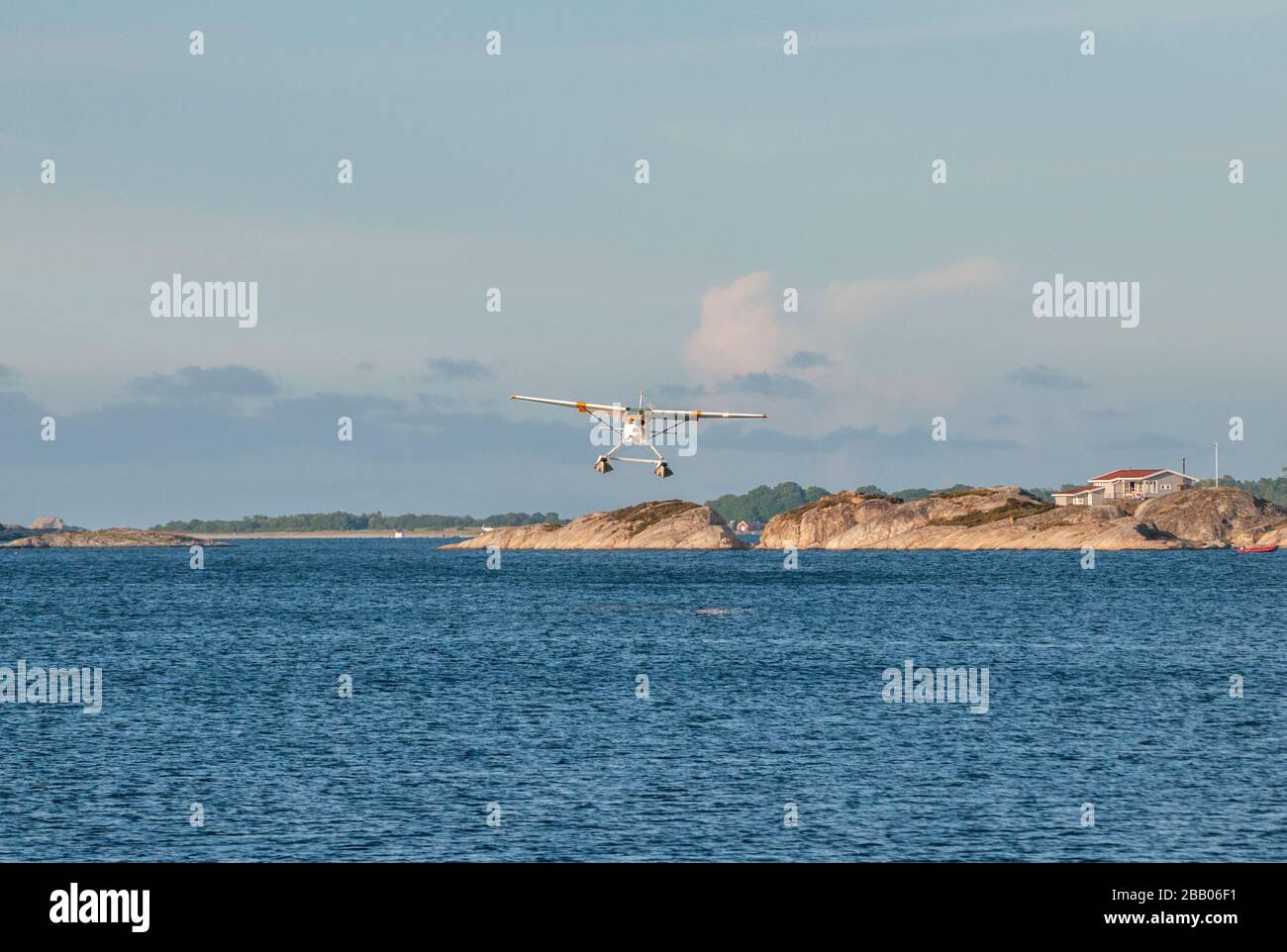 Un hydravion Cessna 172 Skyhawk jaune et blanc qui s'envole parmi les îles de l'archipel de Kragerø, sur la côte sud de la Norvège. Banque D'Images