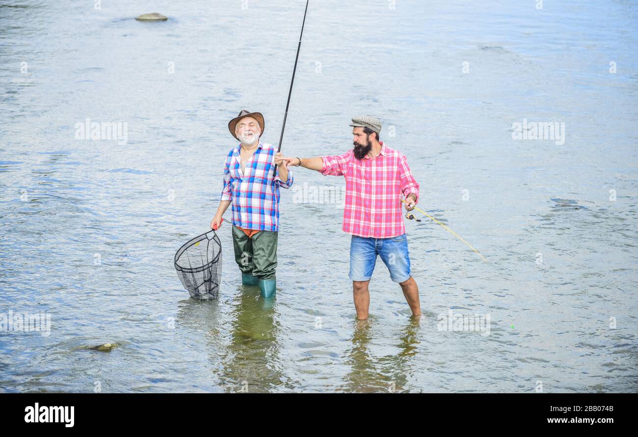 travaillez en équipe. escapade rurale. passe-temps. nature sauvage. deux pêcheurs heureux avec la canne à pêche et le filet. Camping sur la rive du lac. Pêche du père et du fils. Braconnage. Pêche de gros jeux. Amitié. Banque D'Images