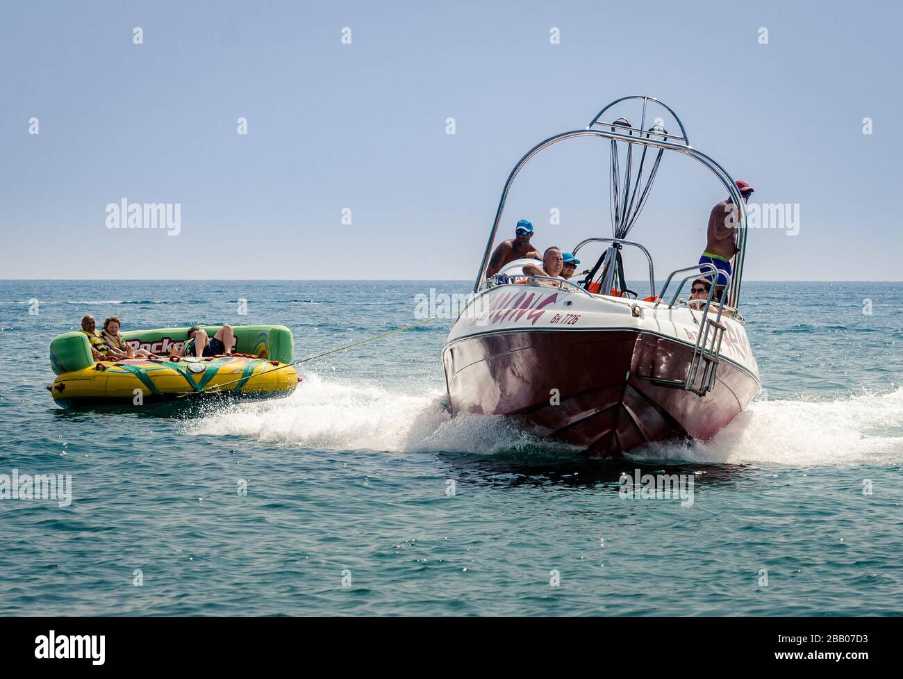 Excitante tubulure d'eau avec Power boat sur la mer noire remorquage vacances frisson les demandeurs sur un grand anneau gonflable en caoutchouc, long shot, Varna Bulgarie Banque D'Images