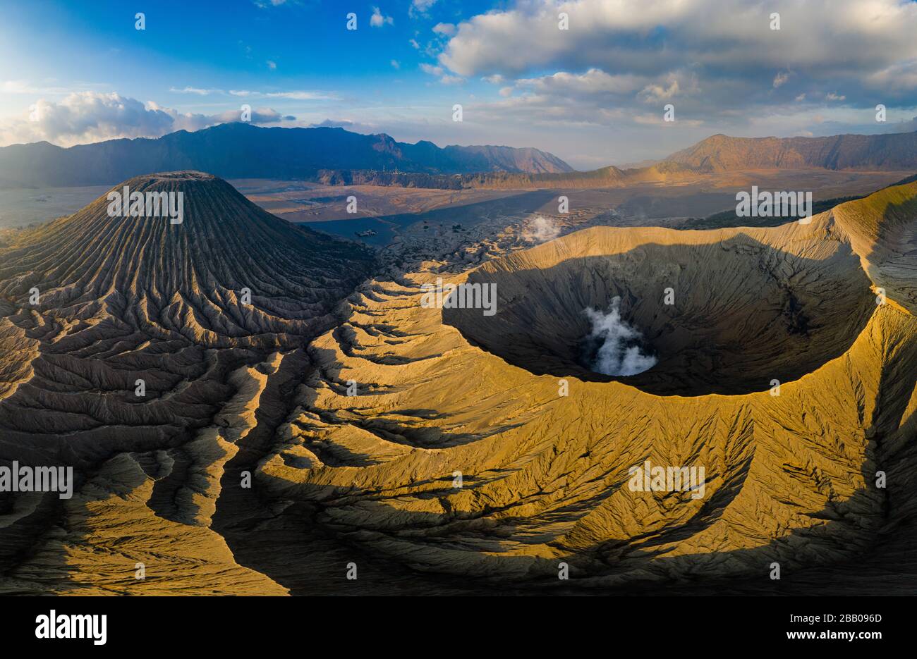 Vue aérienne du gaz qui s'échappe du cratère d'un volcan actif en lumière du soleil dorée, en fin de soirée (Mont Bromo, Java, Indonésie) Banque D'Images