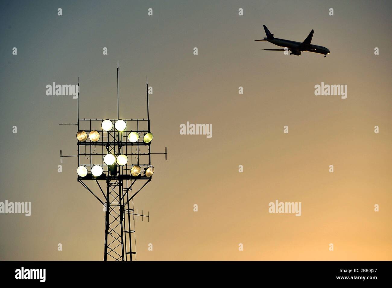 Un avion fait son chemin au-dessus de Griffin Park en direction de Heathrow alors que le soleil se couche. Banque D'Images