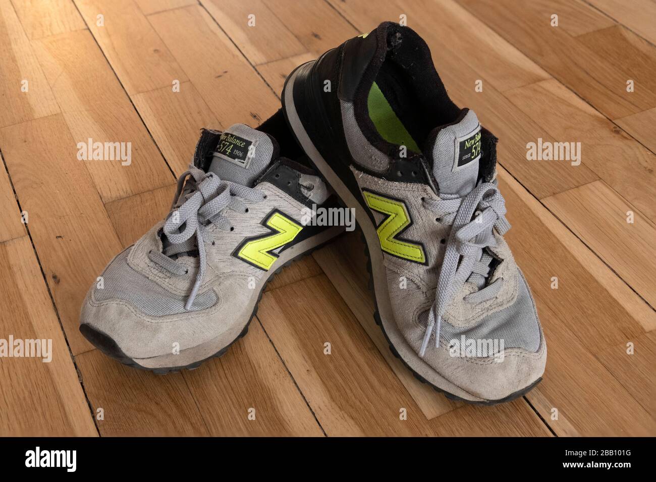 Ancienne paire de chaussures d'entraînement New Balance 574 sur parquet Banque D'Images