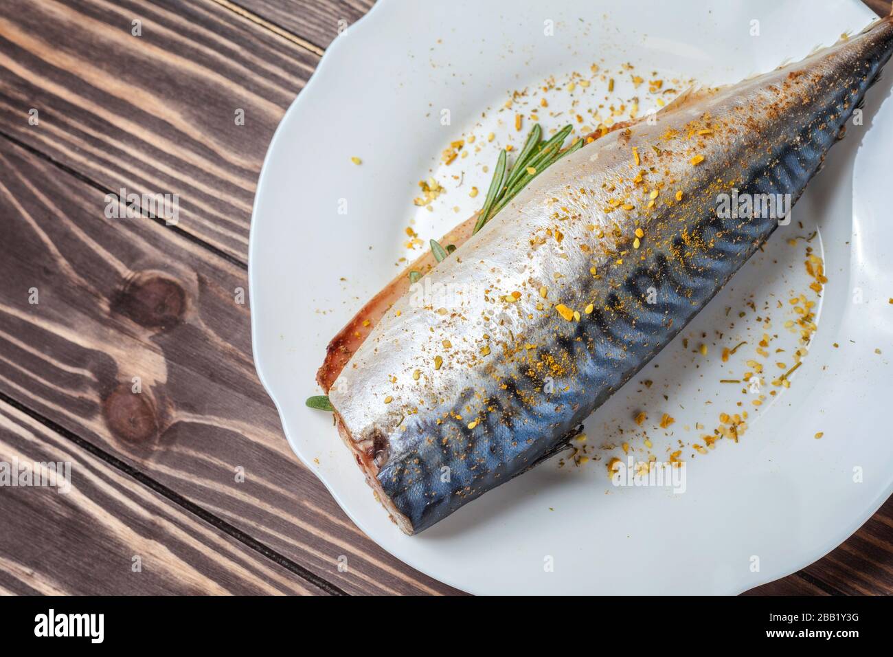 Maquereau mariné dans une plaque blanche. Poisson cru non préparé. Spécialités de fruits de mer traditionnelles, concept de saine alimentation. Sur le fond d'un plan d'examen en bois Banque D'Images