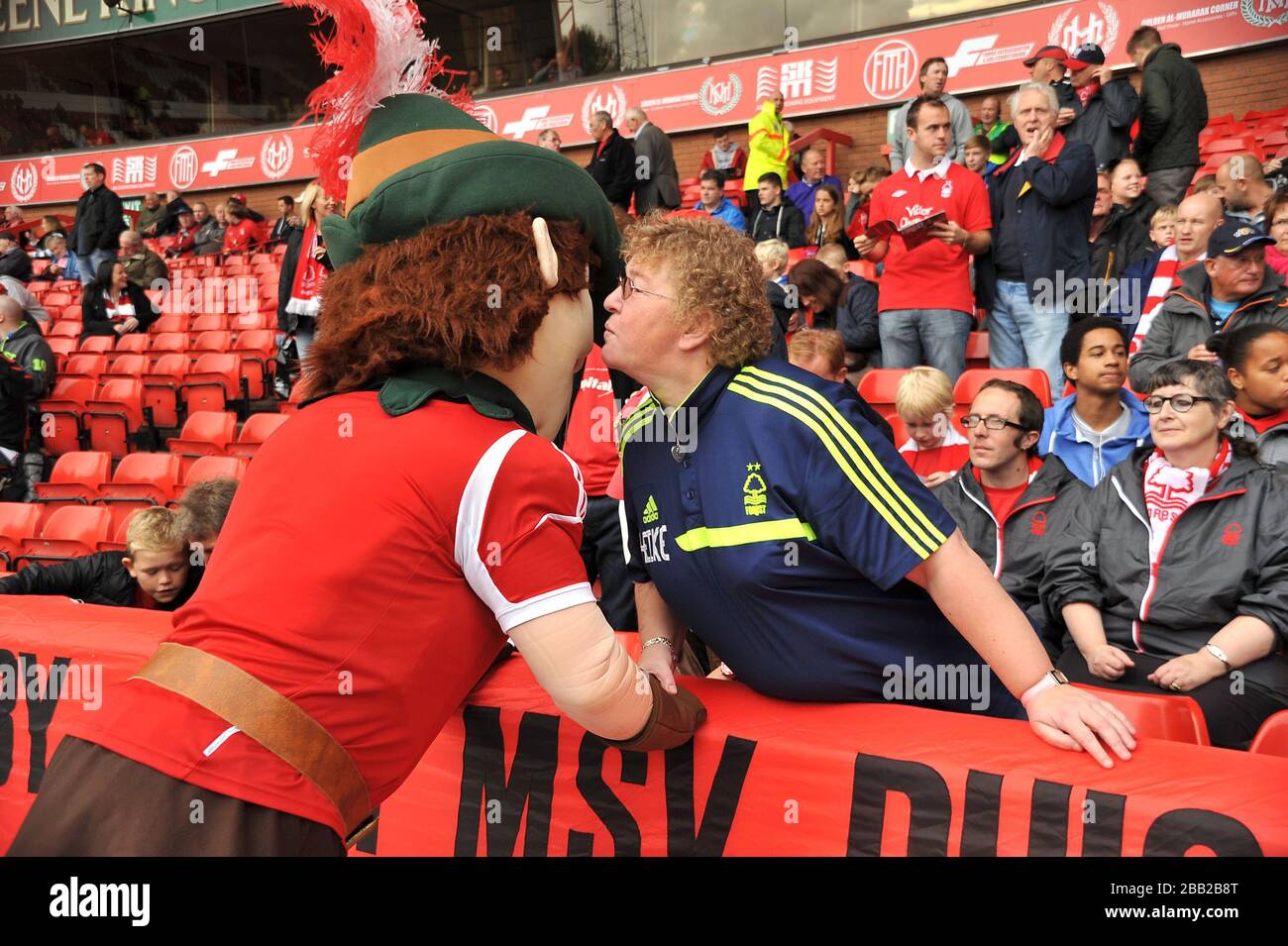 La mascotte de la forêt de Nottingham Robin Hood accueille la femme de Nottingham Forest fan Eberhard 'Ebby' Kleinrensing, Heike avant le jeu Banque D'Images