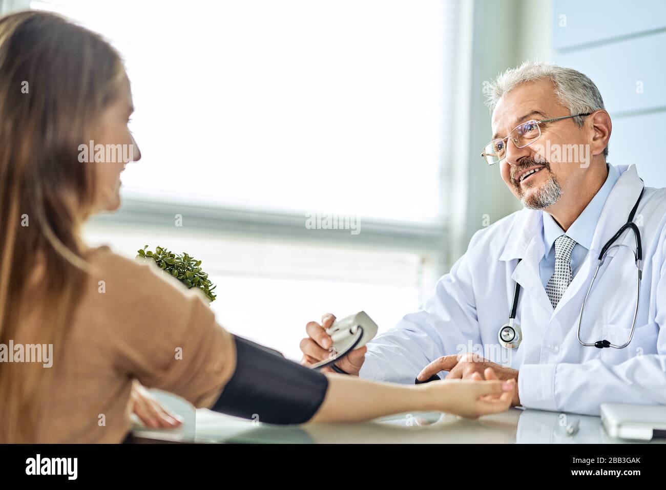 Jeune femme au rendez-vous avec le médecin. Le médecin mesure la pression du patient Banque D'Images