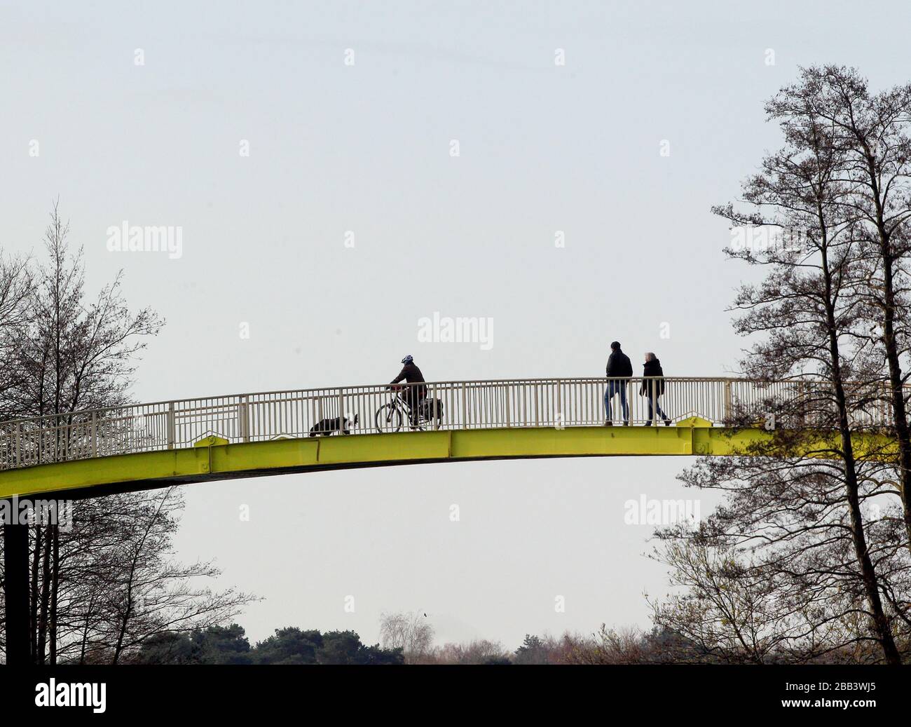 Duisburg, Allemagne. 30 mars 2020. Les gens marchent en binôme sur un pont au Sechsseenplatte. En Rhénanie-du-Nord-Westphalie, il est interdit de réunir plus de deux personnes, à l'exclusion des familles, afin de ralentir la propagation de la pandémie de coronavirus. Crédit: Roland Weihrauch/dpa/Alay Live News Banque D'Images