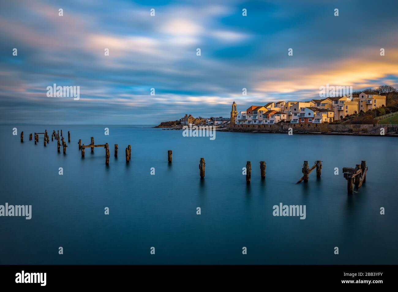 Swanage Pier au coucher du soleil le jour du nouvel an donnant sur les appartements Peveril point. Exposition longue mettant en évidence la beauté de l'ancien quai de Swanage. Banque D'Images