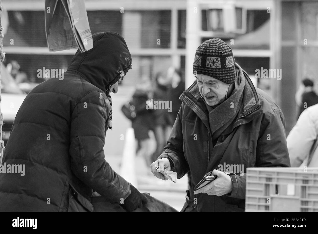 Un homme âgé achète des articles d'épicerie par temps froid à Union Square Greenmarket à Manhattan, New York City, États-Unis d'Amérique Banque D'Images