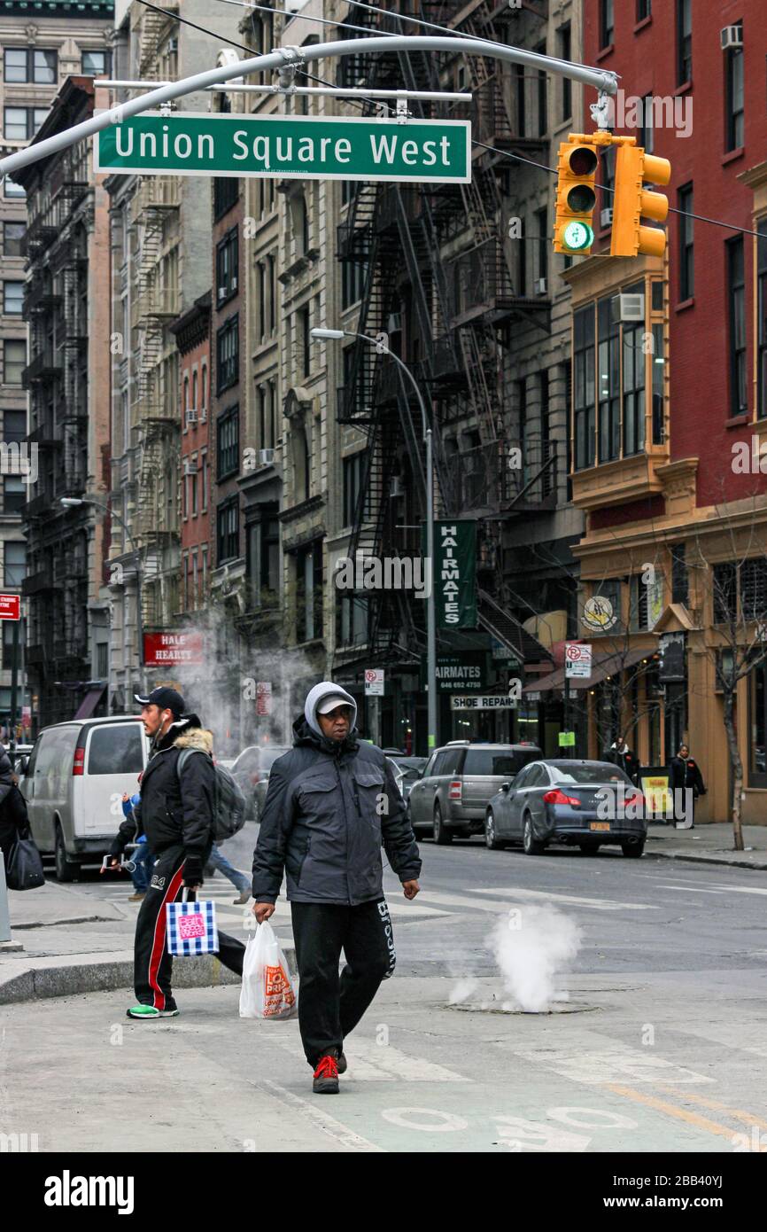 Les gens traversant la rue par Union Square lors d'une journée hivernale froide à Manhattan, New York City, États-Unis d'Amérique Banque D'Images