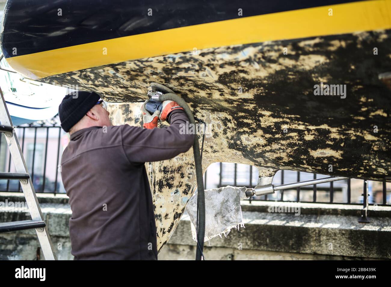 Homme laver la Hull d'un bateau près du lac Léman, Suisse Banque D'Images