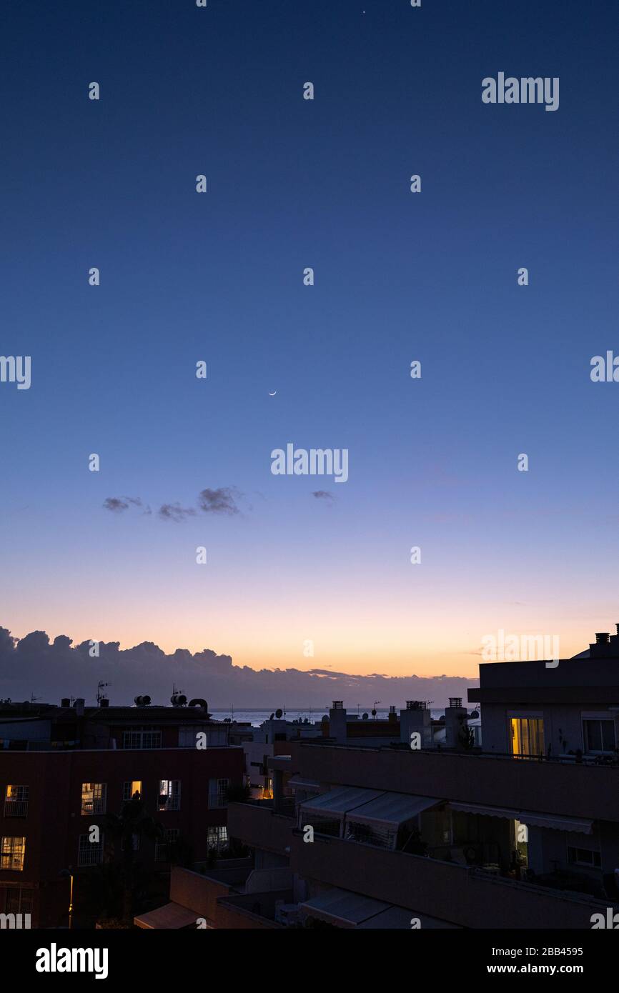 Le croissant de lune et Vénus se dressent au-dessus des lumières des appartements, Playa San Juan, Tenerife, Îles Canaries, Espagne Banque D'Images