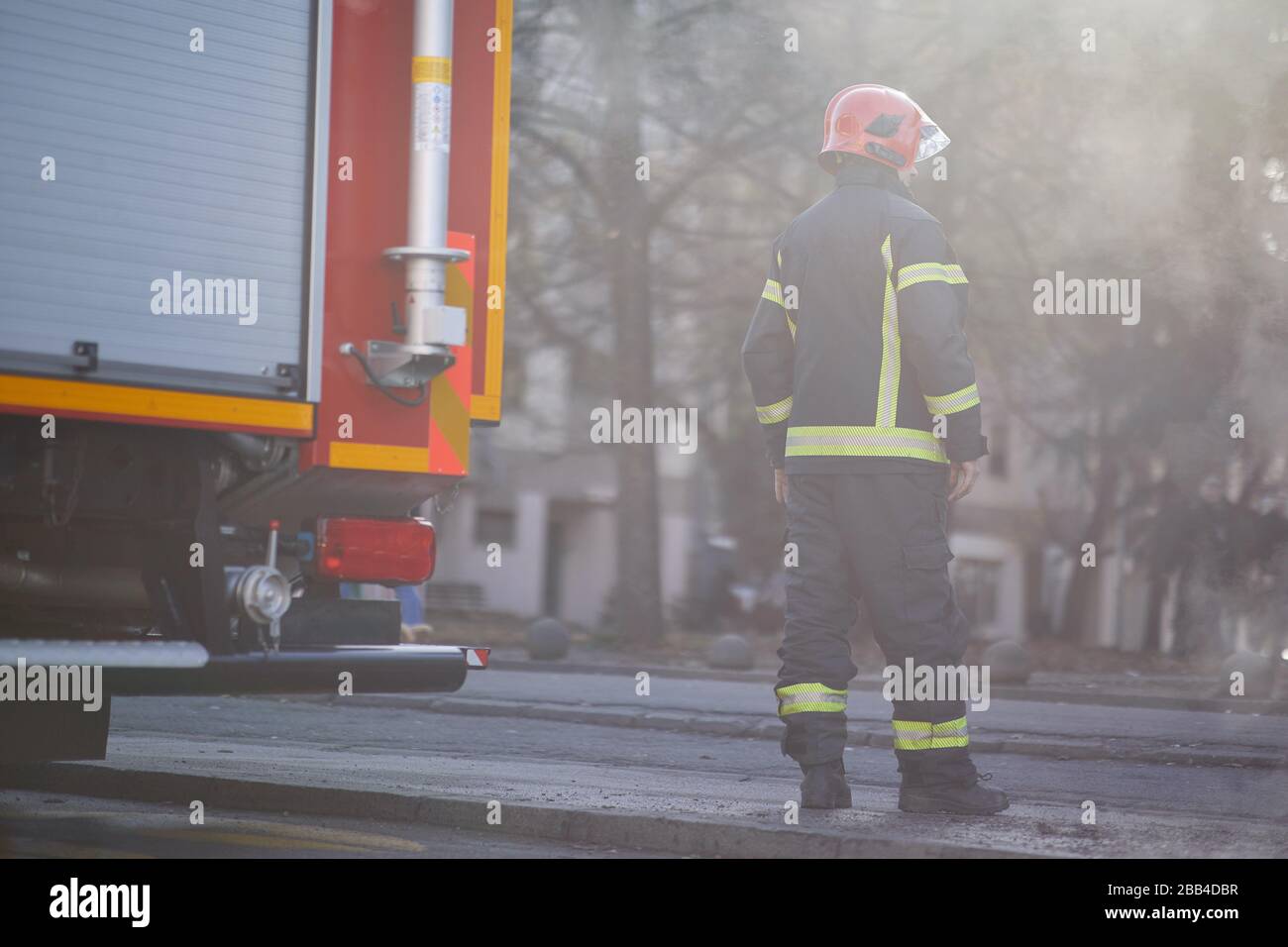 Pompier en uniforme devant un camion de pompiers qui va sauver et protéger. Emergancy , danger, concept de service. Banque D'Images