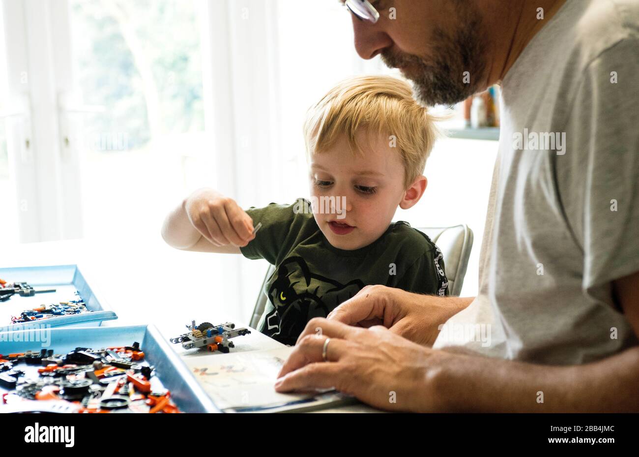 Jack construit quelques lego avec son père, à la maison pendant sa deuxième semaine de fermetures d'écoles en raison du coronavirus. Banque D'Images