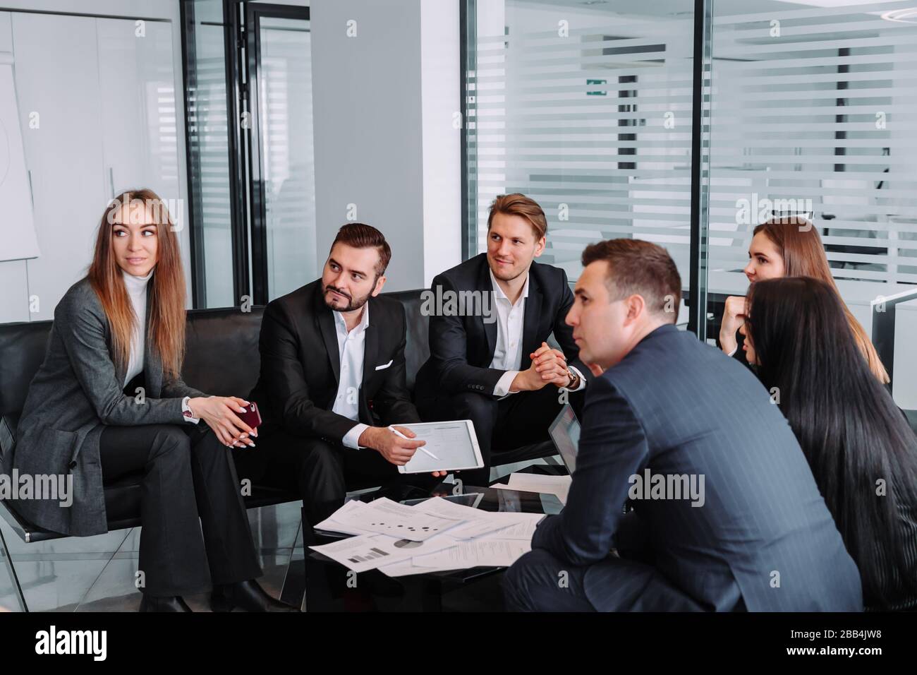 manager discutant du travail avec ses collègues, rencontrer des partenaires commerciaux dans un bureau moderne, un groupe d'hommes d'affaires réussis. Discussion d'un important Banque D'Images