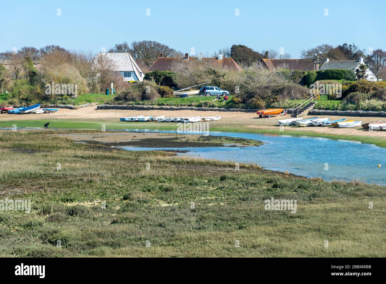 Snowhill Creek à mi-marée devant les maisons de front de mer désirables sur Roman Landing, West Wittering, Chichester, West Sussex, Angleterre, Royaume-Uni Banque D'Images