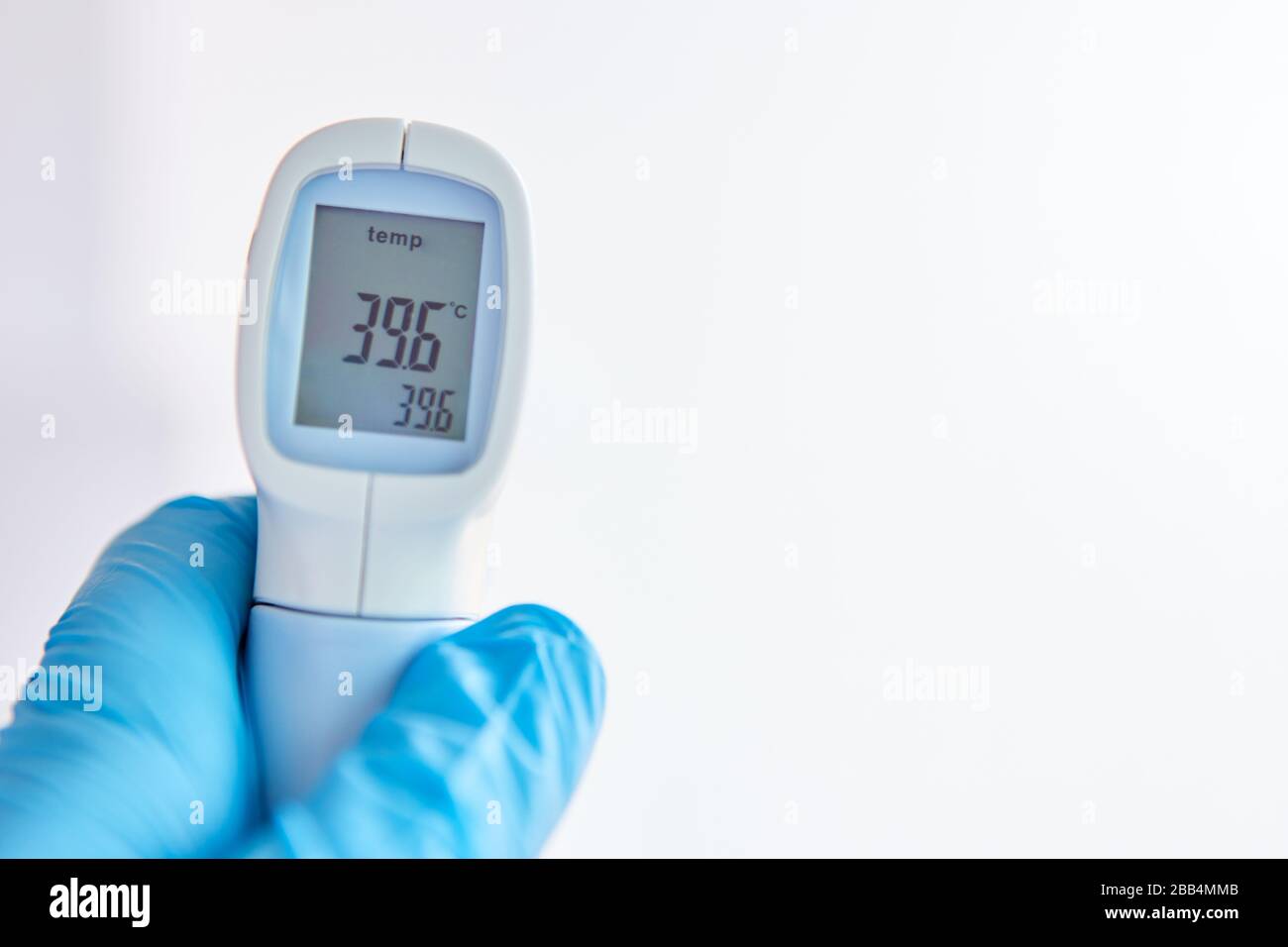L'affichage d'un thermomètre clinique sans contact montre de la fièvre en cas d'épidémie de Covid-19 Banque D'Images