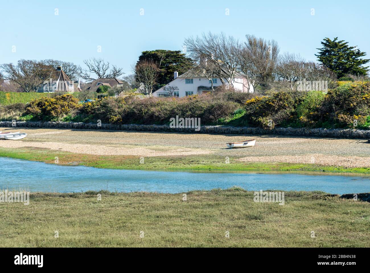 Snowhill Creek à mi-marée devant les maisons de front de mer désirables sur Roman Landing, West Wittering, Chichester, West Sussex, Angleterre, Royaume-Uni Banque D'Images