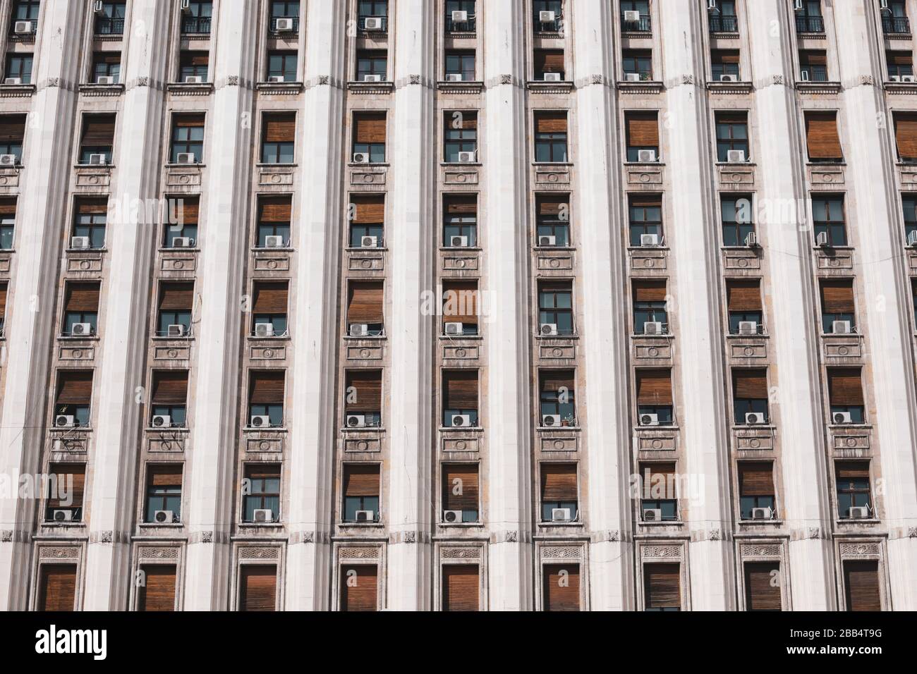 L'extérieur d'un ancien bâtiment de style soviétique avec des machines de climatisation à fenêtre. Banque D'Images