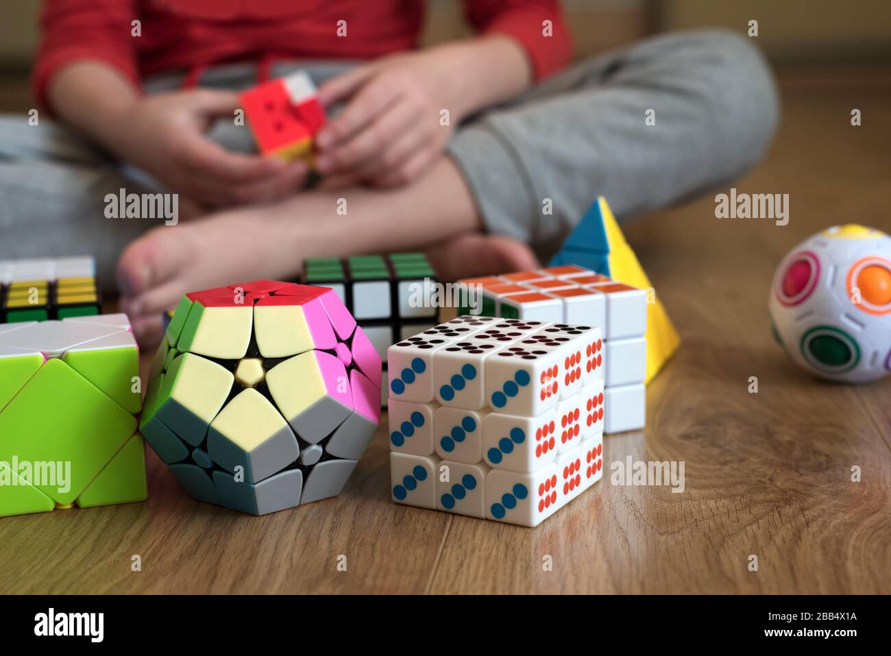 Mains de garçon essayant de résoudre le puzzle contre divers pyramide et  cube jouet puzzles fond. Résoudre des tâches difficiles ou rester à la  maison concept. Doux Photo Stock - Alamy