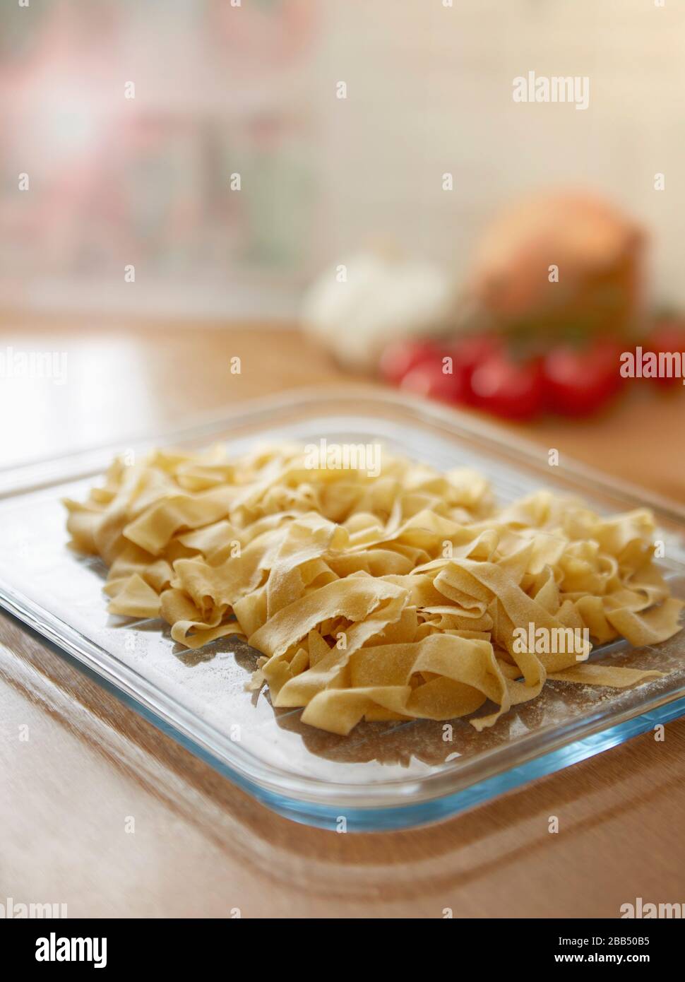 maison fait des pâtes tagliatelles fraîches dans la cuisine sur plateau en verre sur le plan de travail de cuisine Banque D'Images