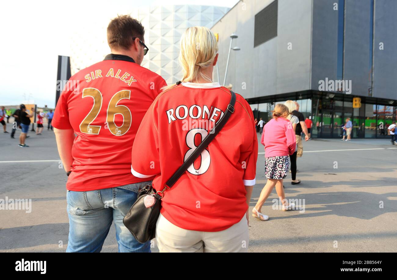 Les fans de Manchester United avec les noms « ir Alex » et « Rooney » au dos de leurs chemises marchent vers le stade Friends Arena Banque D'Images