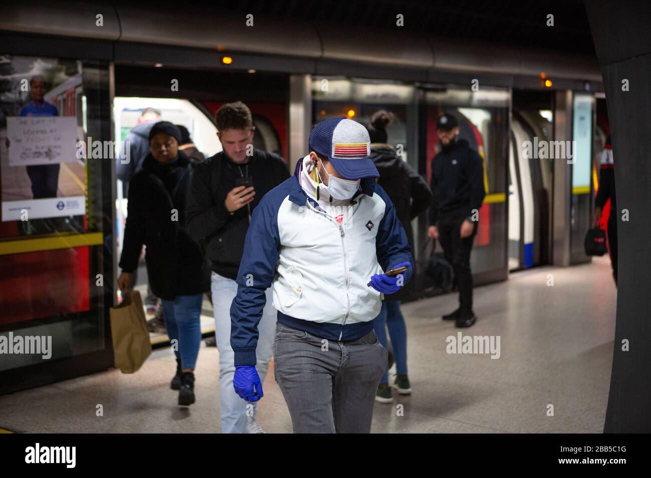 Les navetteurs portent des masques sur le métro londonien lors de l'éclosion de COVID-19. Mars 2020 Banque D'Images