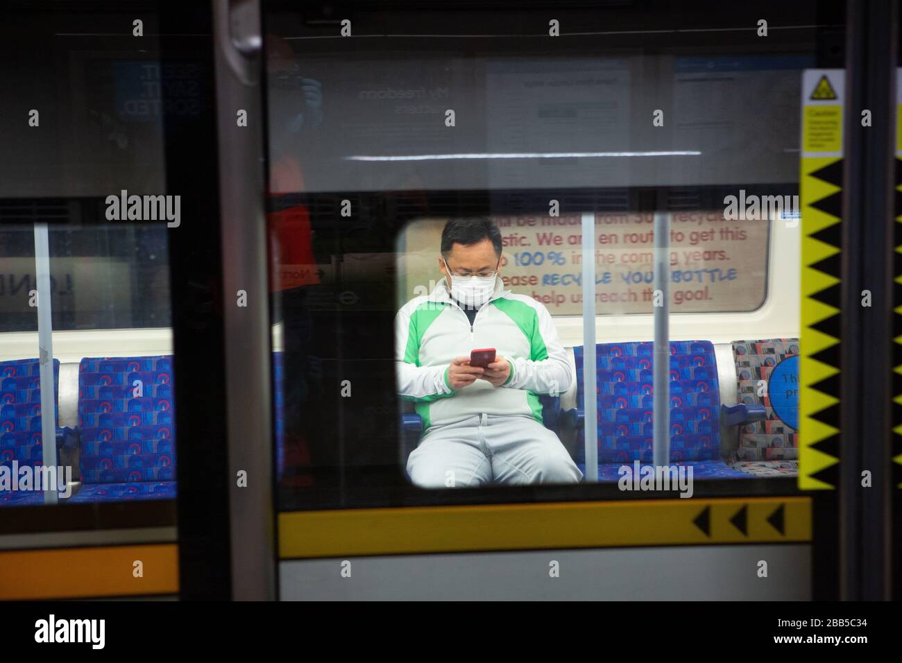 Les navetteurs portent des masques sur le métro londonien lors de l'éclosion de COVID-19. Mars 2020 Banque D'Images