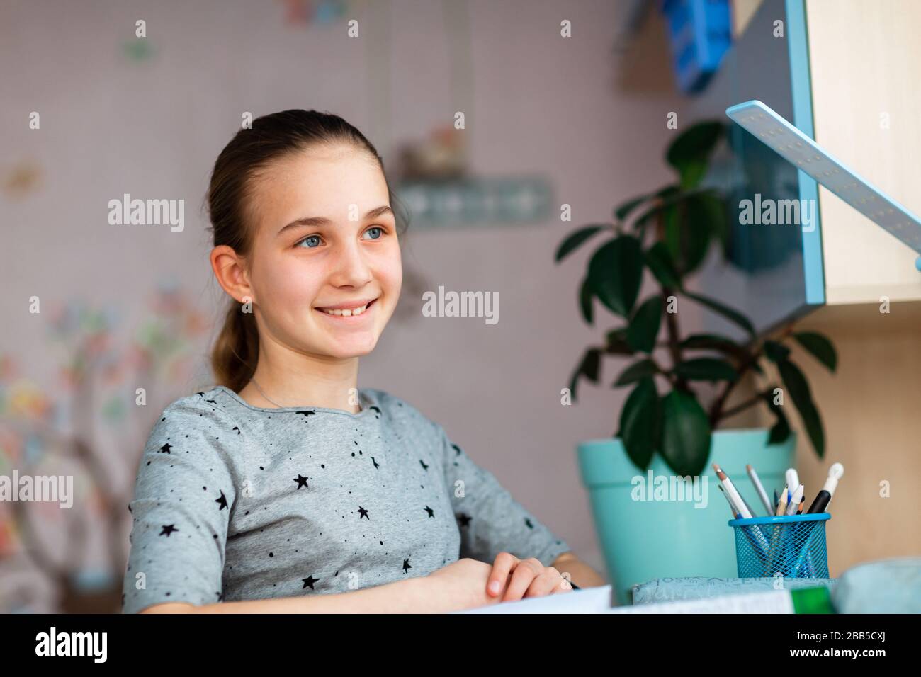 Belle jeune fille d'école travaillant à la maison dans sa chambre avec notes de classe et téléphone mobile et étudier. Concept d'enseignement et d'apprentissage à distance pendant Banque D'Images