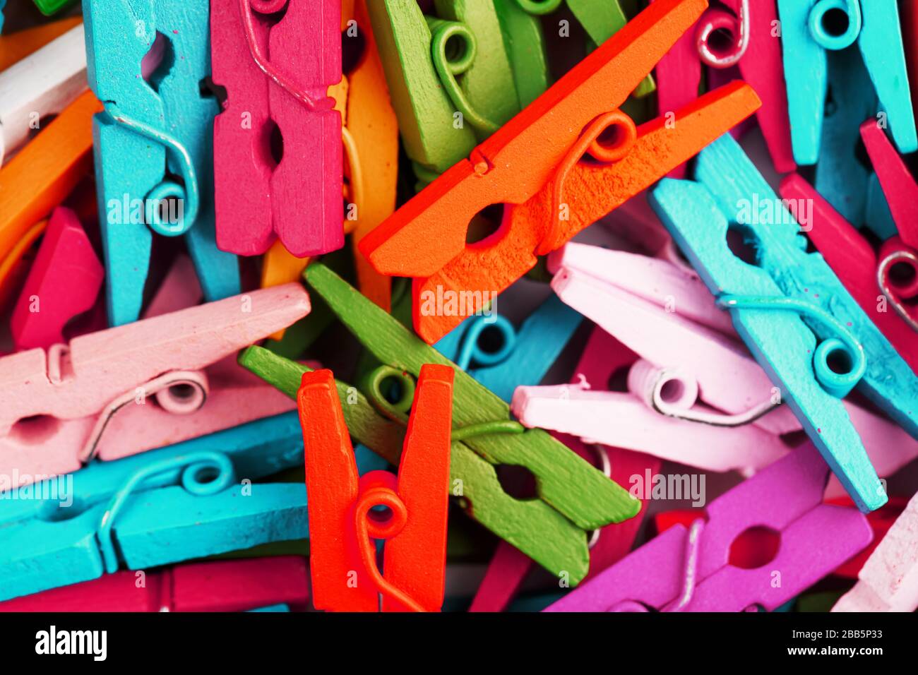 Les clothespins en bois colorés se rapprochés comme une texture et un fond en plein écran. Banque D'Images