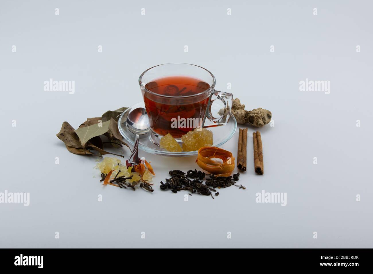 Gros plan d'une tasse de tisanes et de diverses herbes sur fond blanc Banque D'Images