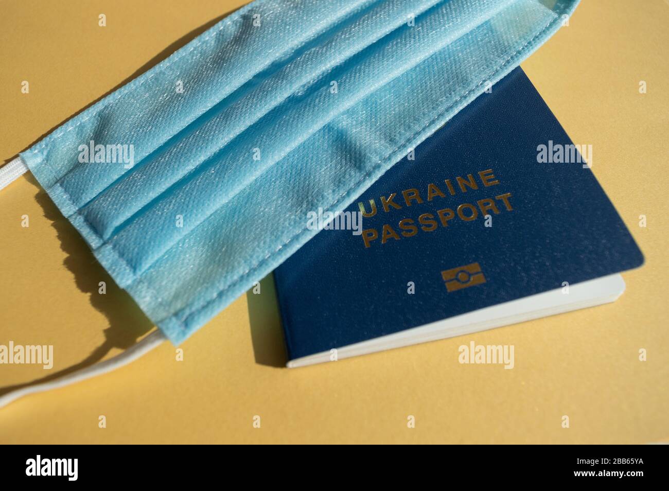 Passeport Forein de l'Ukraine sous des masques médicaux bleu clair sur les milieux jaune vif contre le virus covid-2019. Concept de soins de santé, arrêt Banque D'Images