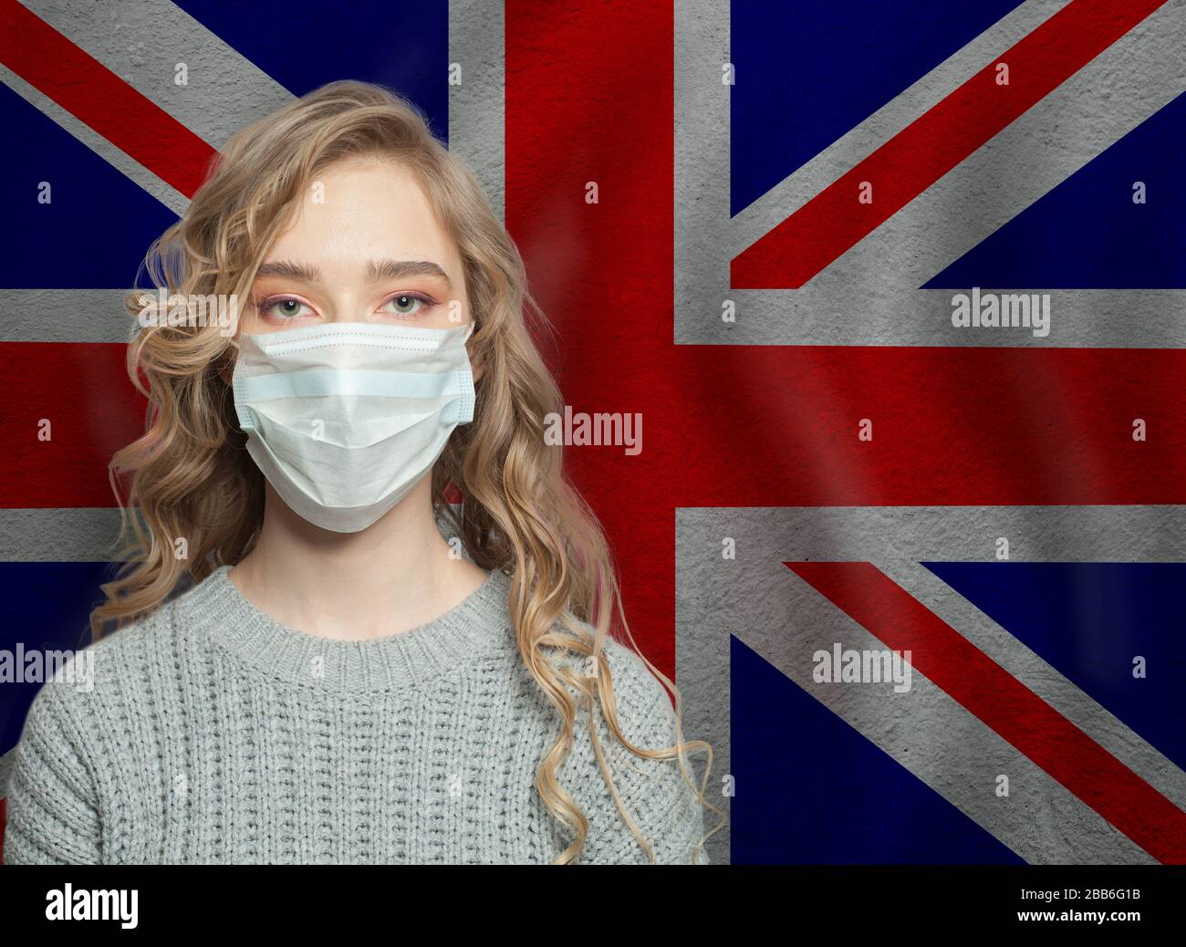 Femme sérieuse portant un masque facial contre le drapeau britannique. Concept d'épidémie de grippe et de protection contre les virus Banque D'Images