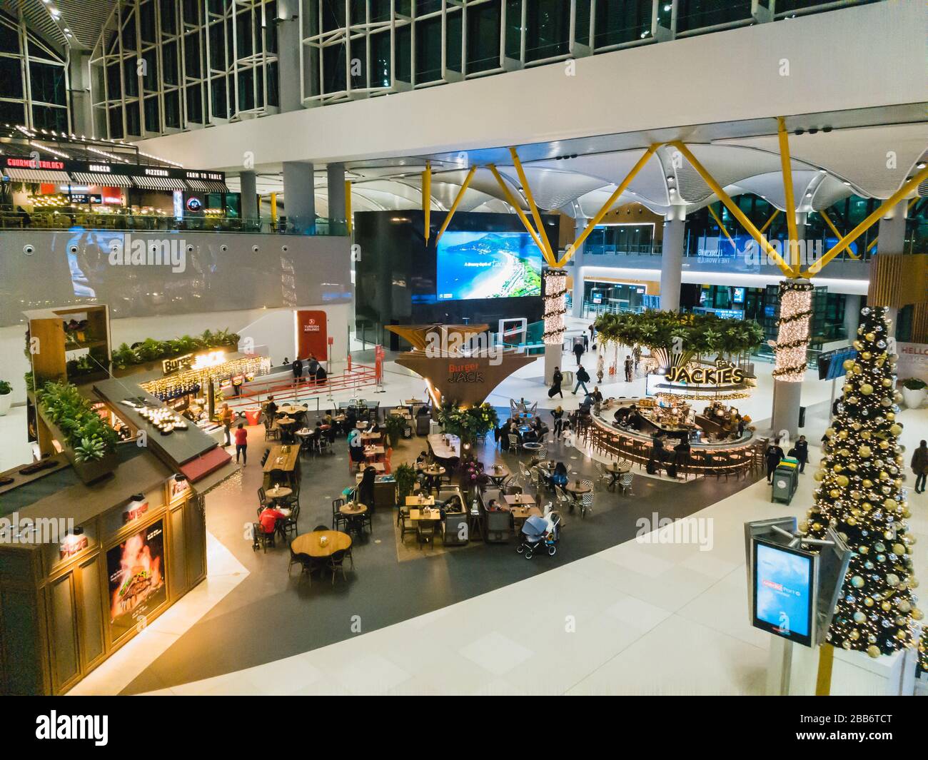 Istanbul, Turquie - 11 février 2020: Passagers dans la salle de départ de l'aéroport IGA Istanbul assis dans les cafés Burger Jack et Jackies, vue de dessus Banque D'Images