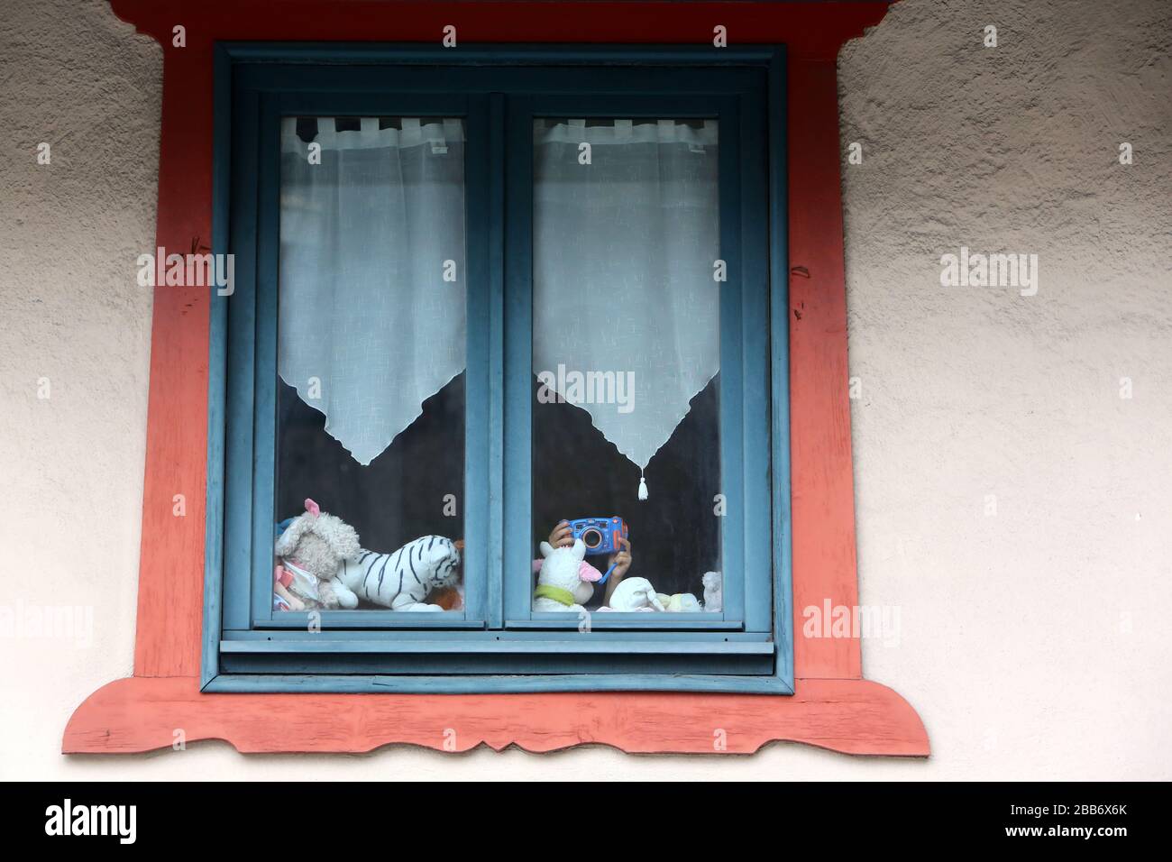 Enfant derrière une fenêtre de votre fils fourré photo. Jouet. Saint-Gervais-les-bains. Haute-Savoie. France. Banque D'Images