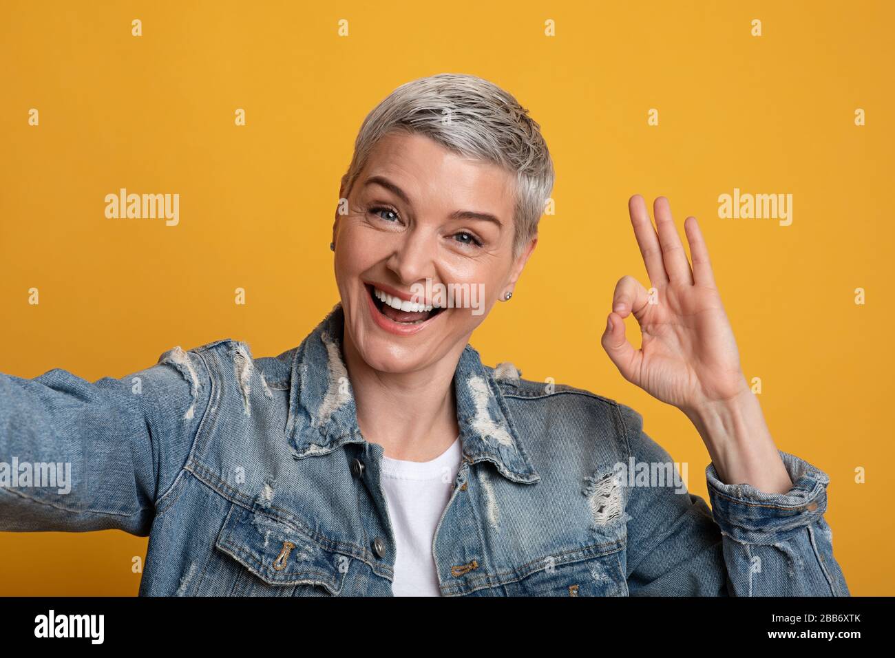 Tout va bien. Gai femme d'âge moyen prenant Selfie et montrant la Gesture d'Okay Banque D'Images