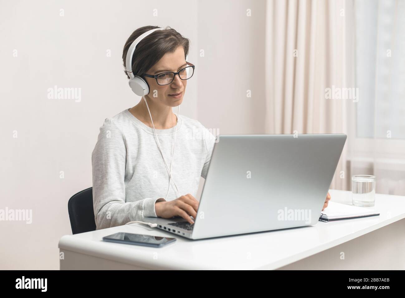 Une femme indépendante étudie le chat en ligne, en parlant tout en étant assis à la maison. Vidéoconférence. Banque D'Images