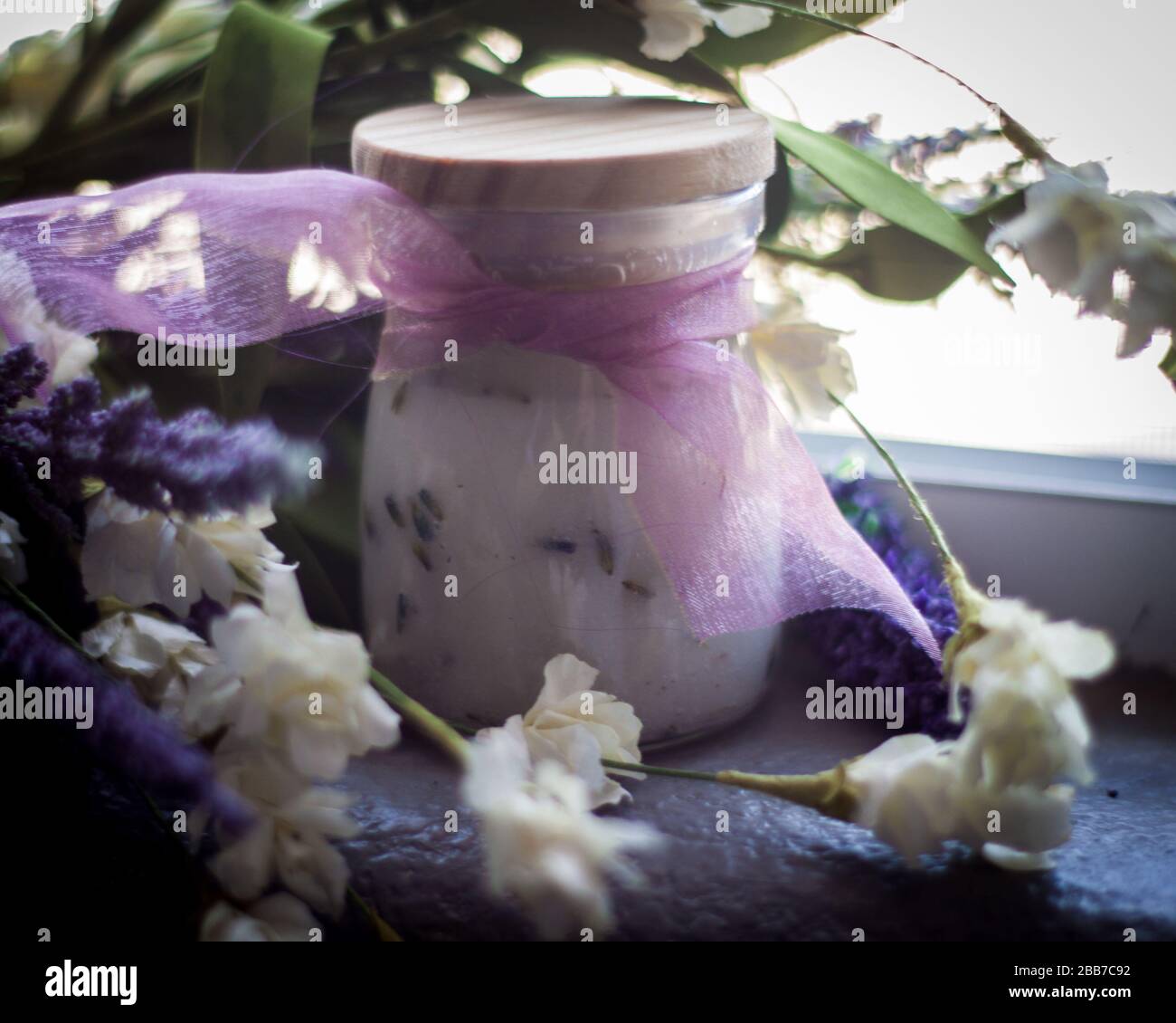 Bol à gommage au sucre avec ruban violet, lavande et fleurs blanches Banque D'Images