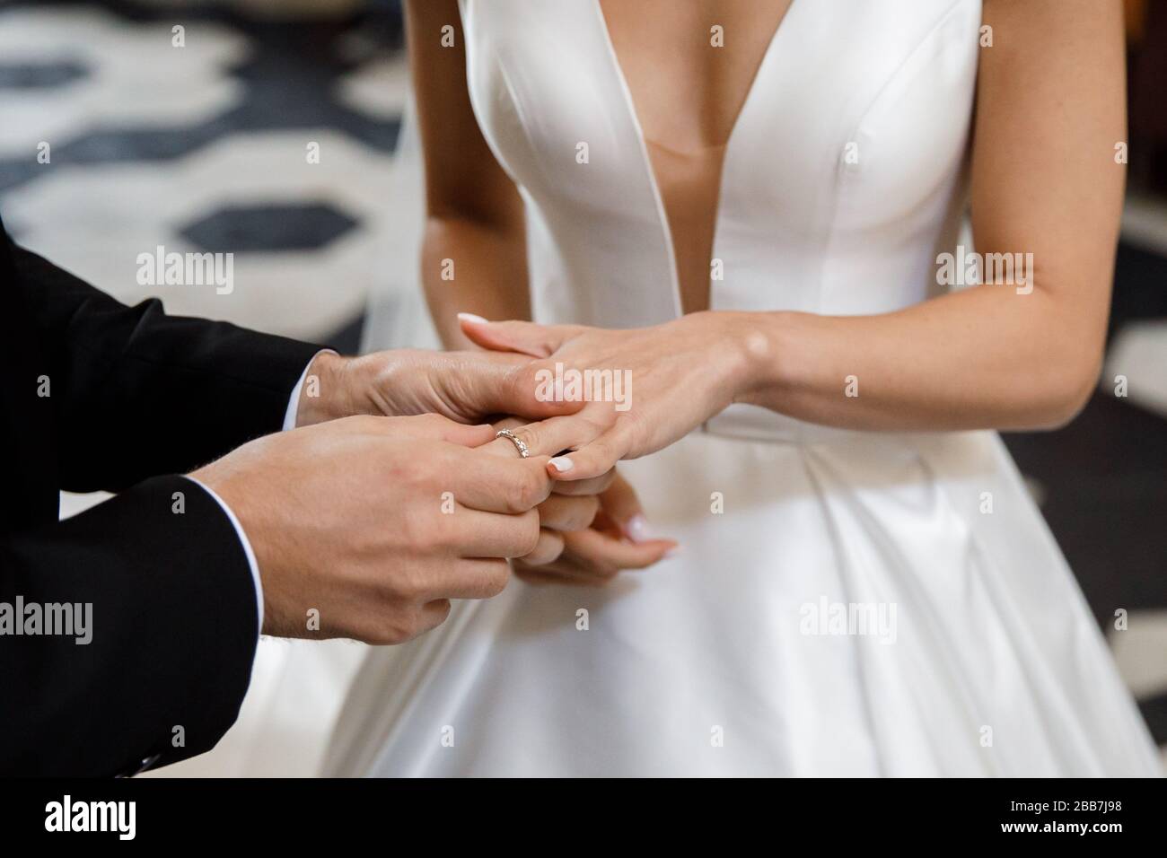 Couple dans mariage attyre échanger des anneaux avec un bouquet de fleurs dans l'église. La mariée et le marié Banque D'Images