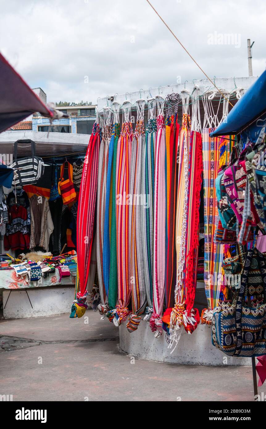 OTAVALO, EQUATEUR - 28 JUILLET 2018: Un vendeur de rue vendant un assortiment de beaux tissus. Banque D'Images