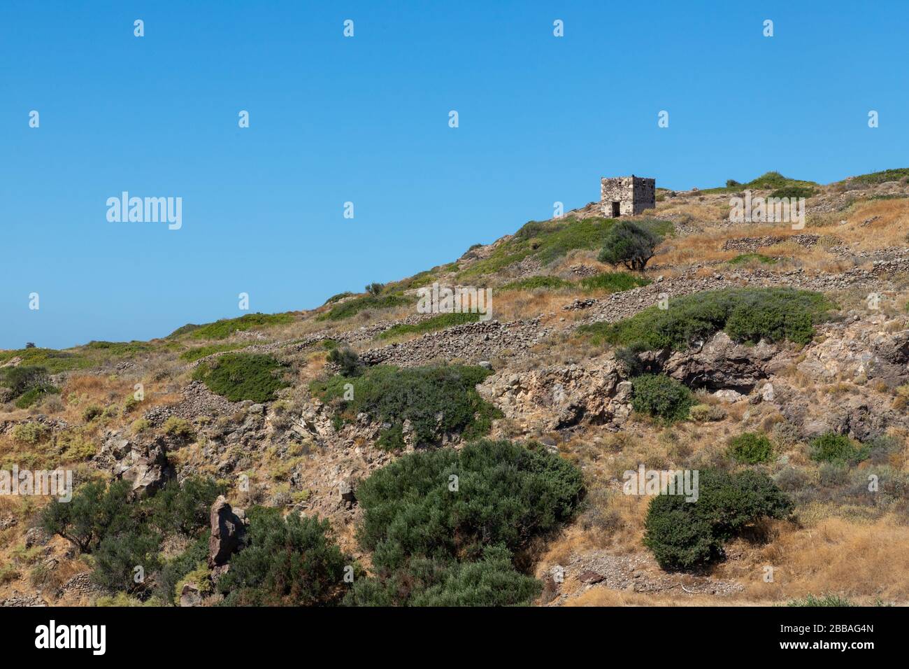 Mur de pierre avec végétation et ruines à Trypiti, Milos, Grèce Banque D'Images