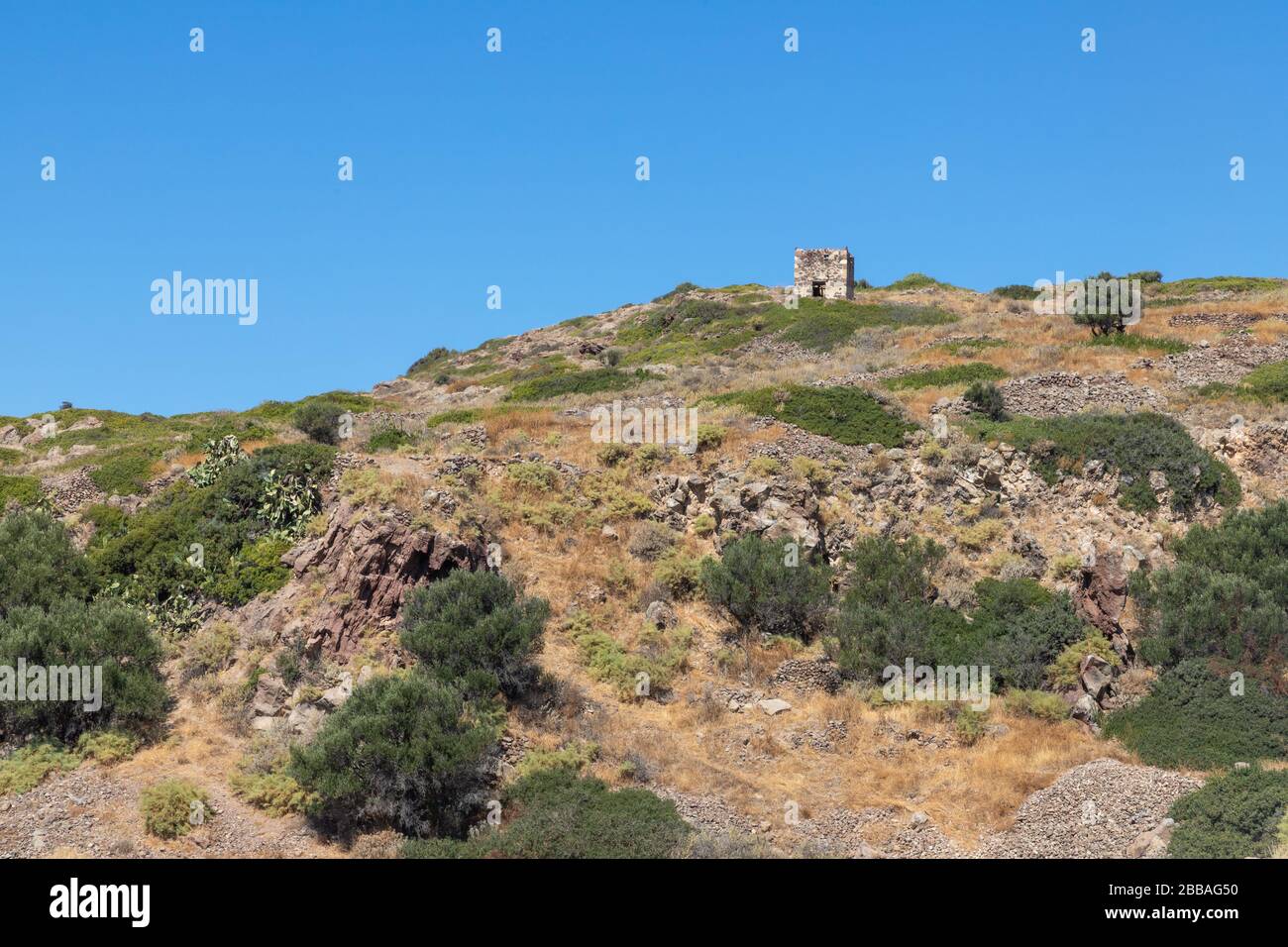 Mur de pierre avec végétation et ruines à Trypiti, Milos, Grèce Banque D'Images