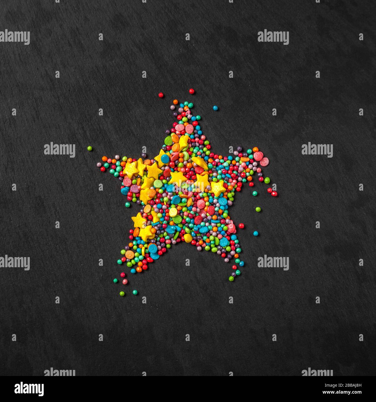 Saupoudrez le fond en forme d'étoile. Saupoudrez sous forme de rayures, de boules, d'étoiles sur fond noir. Espace de copie. Concept d'un plan de Pâques. Photo de vue de dessus Banque D'Images